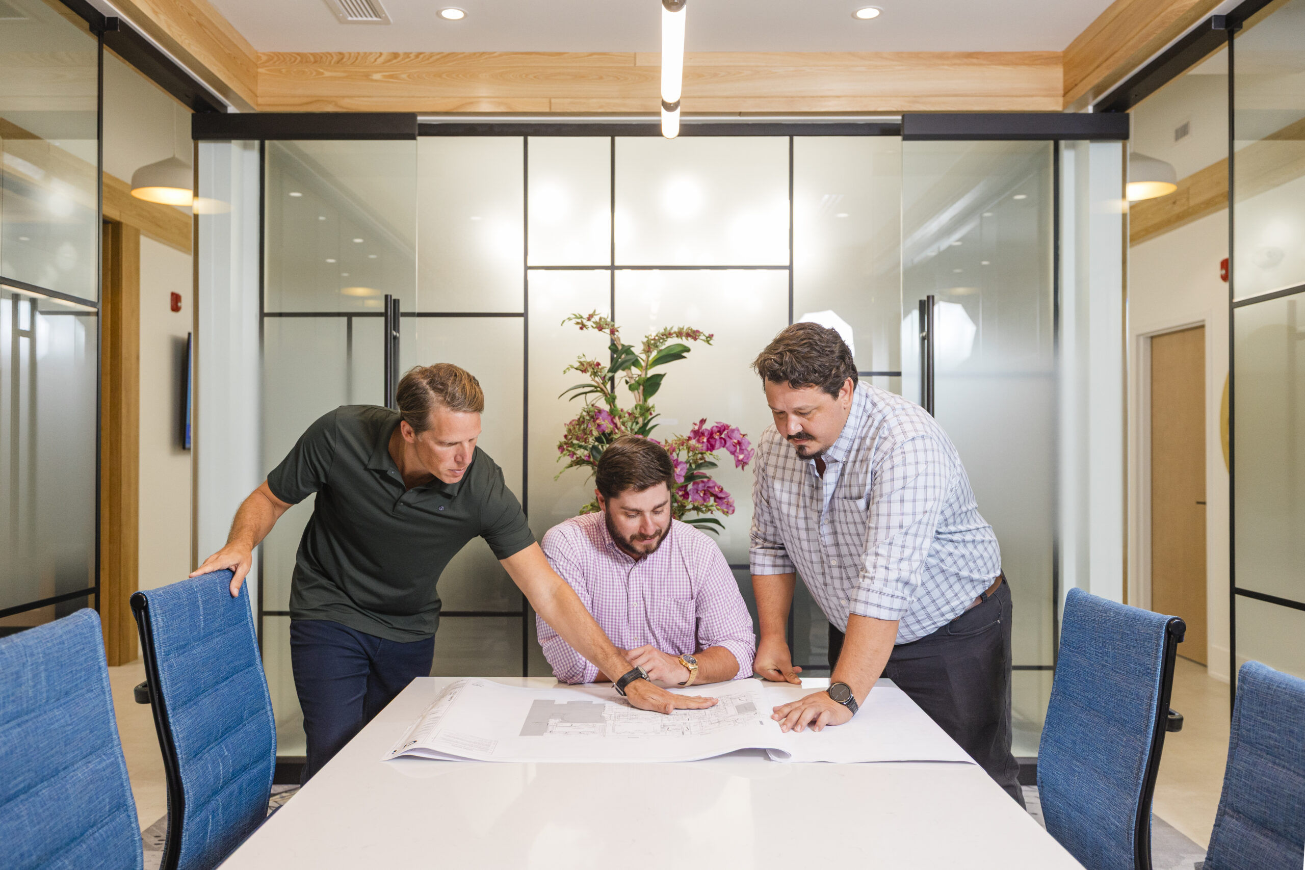 Development team at Evolve Companies reviews blueprints in meeting room at Wilmington, NC headquarters.